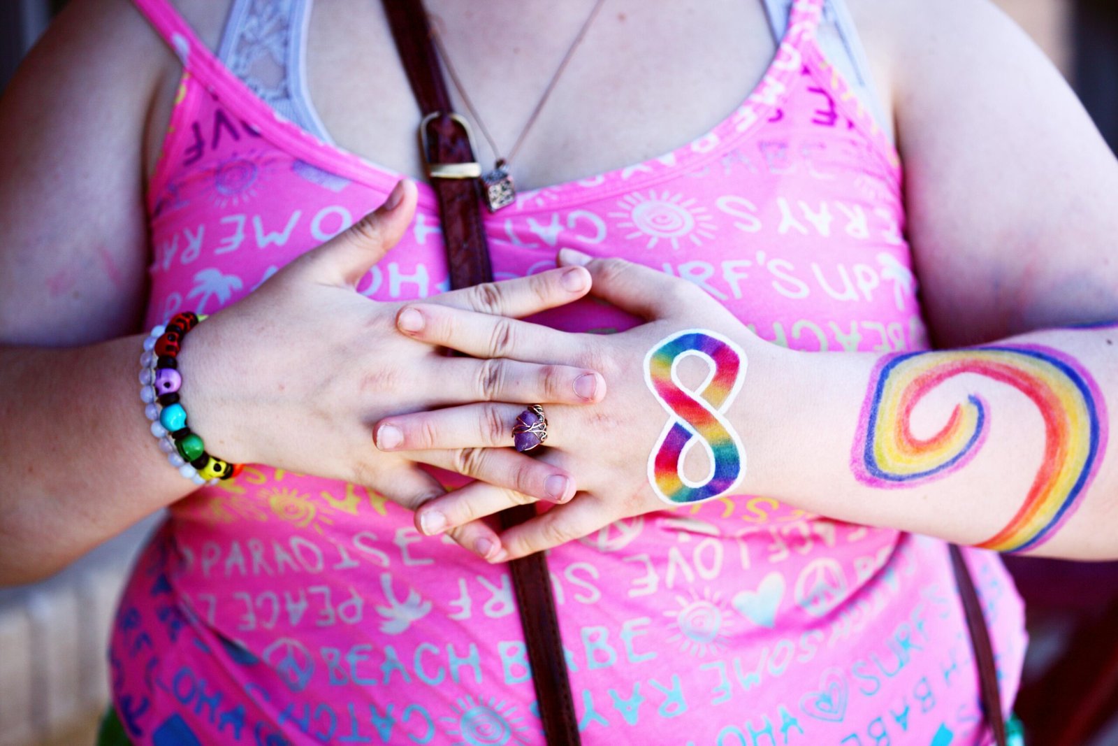 A woman displaying rainbow body paint and holding hands symbolizing diversity and inclusion, obésité, causes, stress