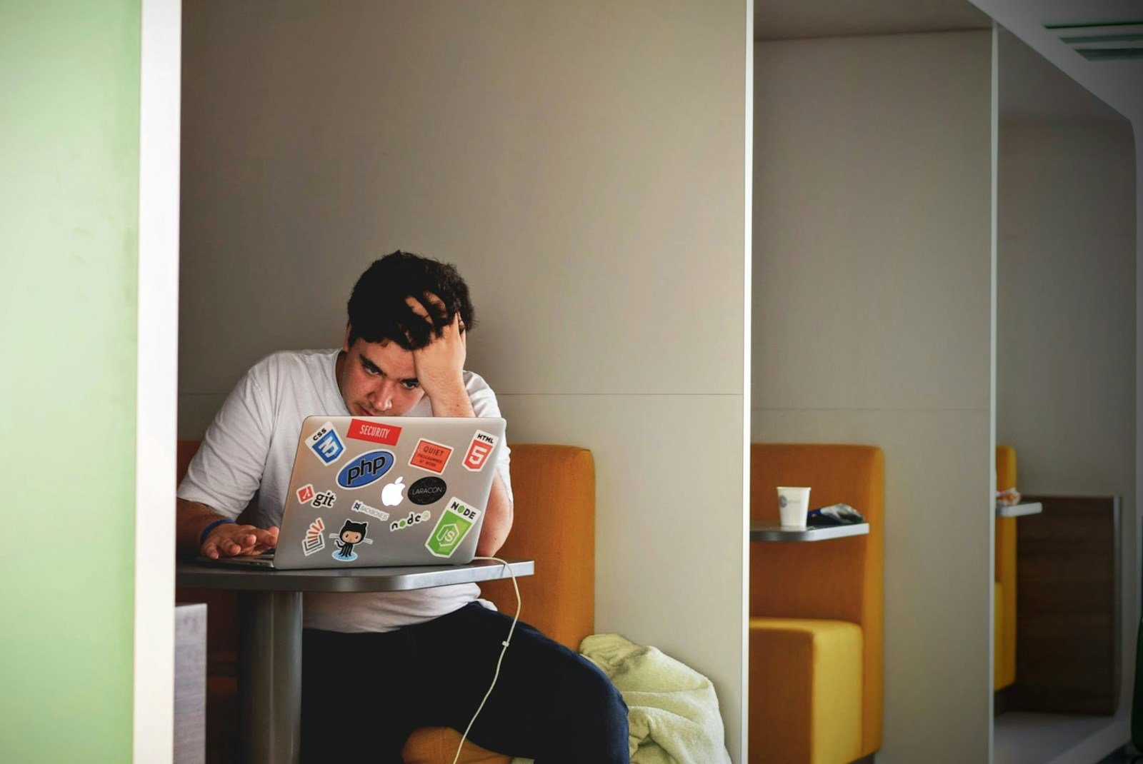 man wearing white top using MacBook, stress, no relax
