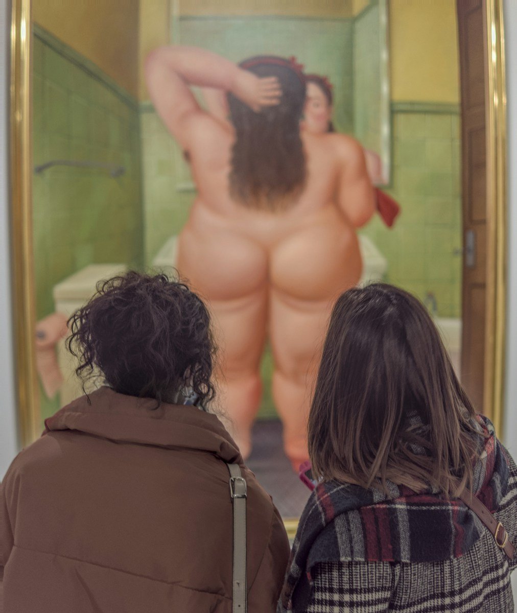 a couple of people that are looking at a painting, obésités, causes