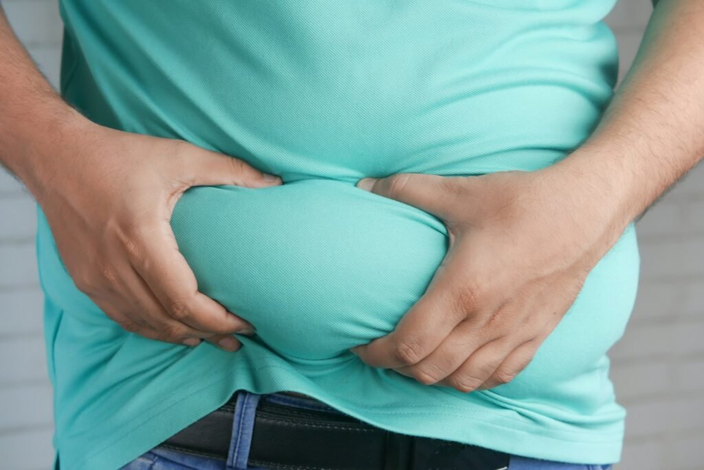 a man holding his stomach with his hands, gras, excès alimentaire, stress chronique