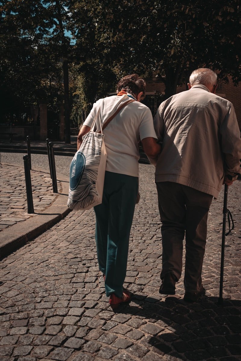 man in brown shirt and blue denim jeans standing beside woman in white long sleeve shirt