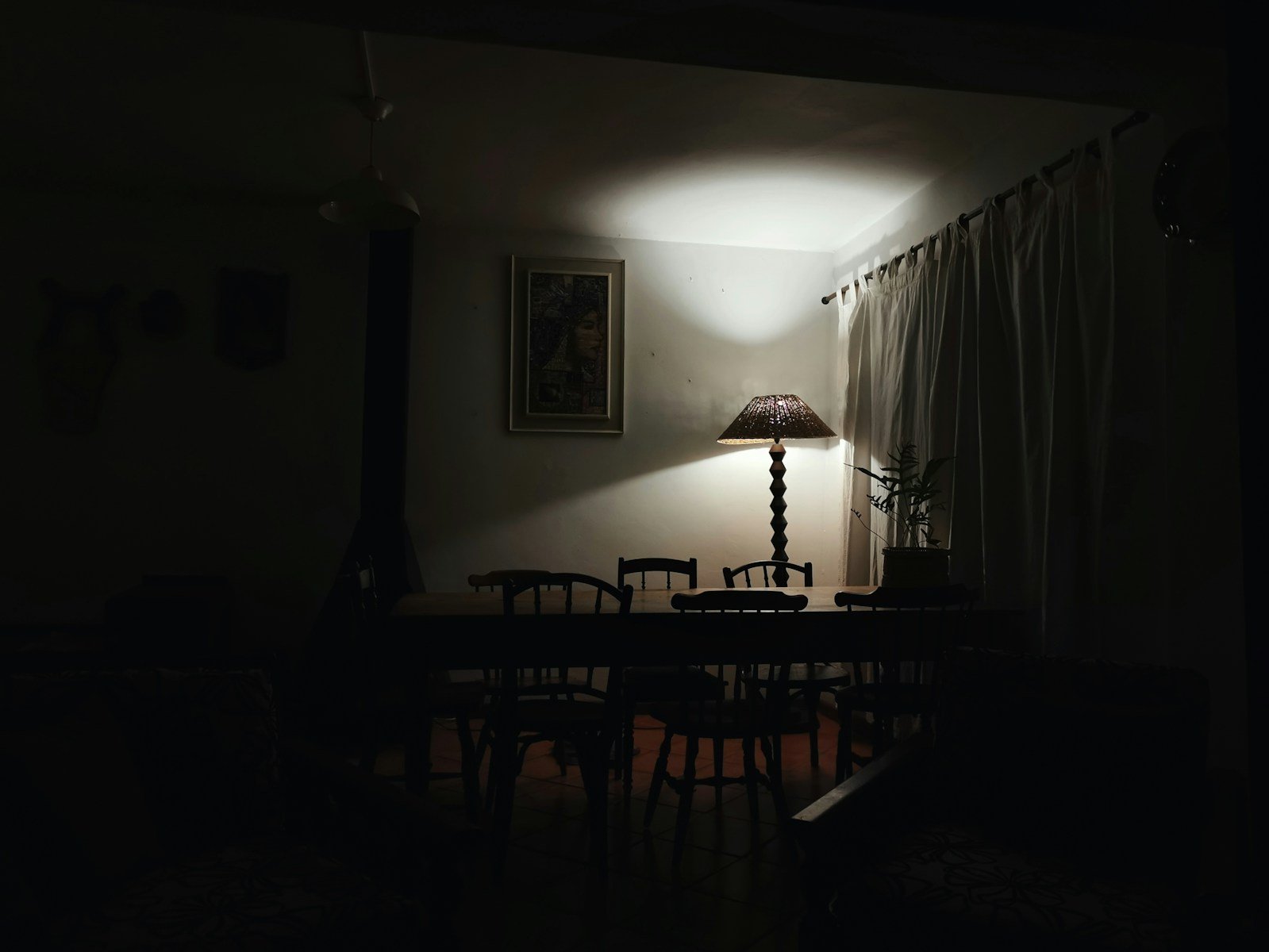 a dark room with a table and a lamp