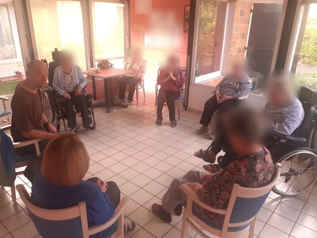 Sébastien Moussu anime un atelier en cercle avec des résidents, dont certains en fauteuil roulant